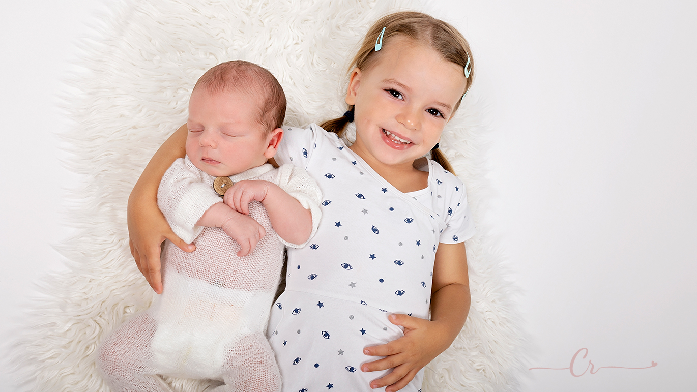 Séance photo au studio avec une fratrie, fille et garçon. Les deux habillés en blanc. Photo prise au studio de Pezilla-la-Riviere de Carolina Rubio Photography.