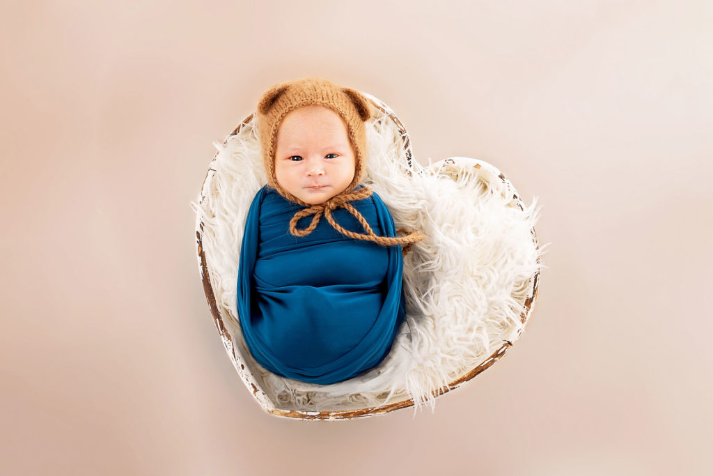 Photo d’un bébé éveillé dans un lit en forme de cœur, studio Carolina Rubio Photography à Pézilla-la-Rivière